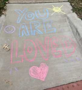 "You Are Loved" written in chalk on a sidewalk