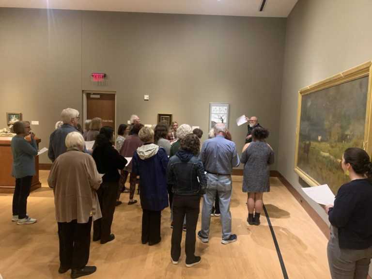 Image of a group of docents looking at a large artwork in a gallery.