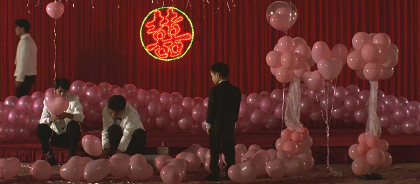 A Film Still from Edward Yang's Yi Yi that shows pink balloons in a red room.