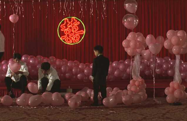 A Film Still from Edward Yang's Yi Yi that shows pink balloons in a red room.