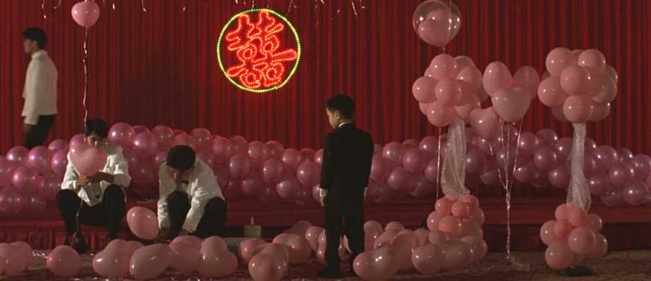 A Film Still from Edward Yang's Yi Yi that shows pink balloons in a red room.