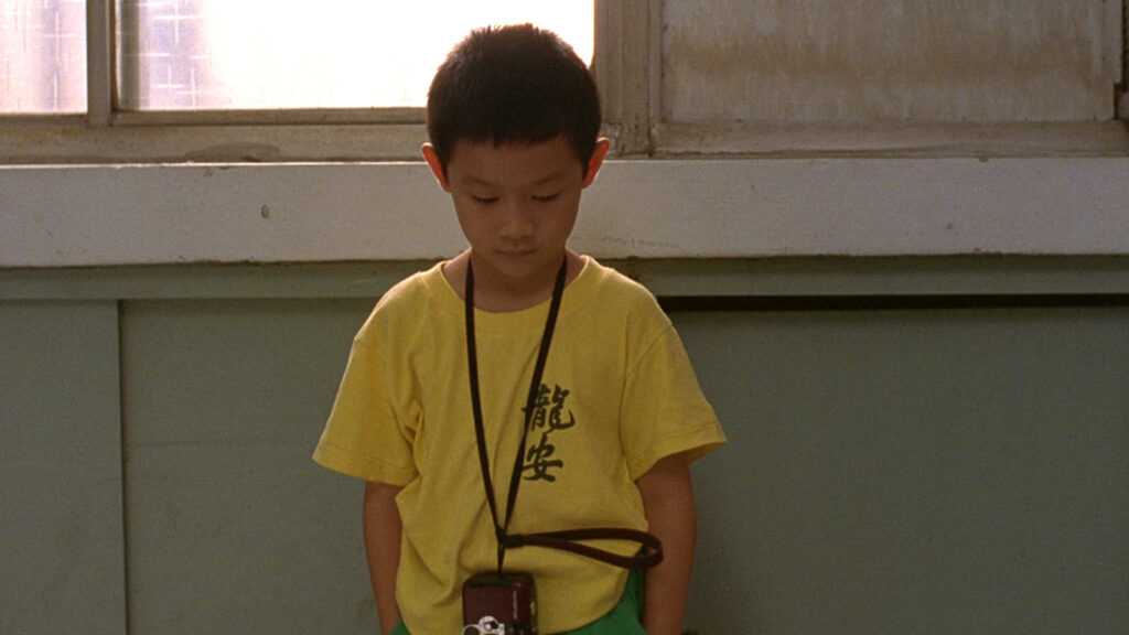 Film Still from Edward Yang's Yi Yi that shows a little boy in a yellow t-shirt. 