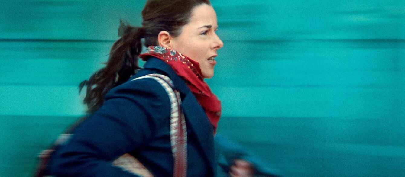 A film still from Full Time with Laure Calamy running against a blue background.