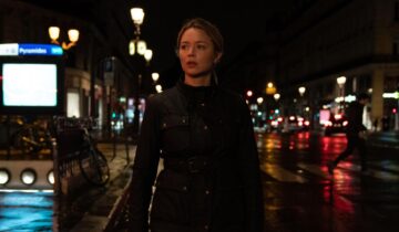 A Film Still from Revoir Paris with Virginia Efira wearing a leather jacker on a nighttime street.