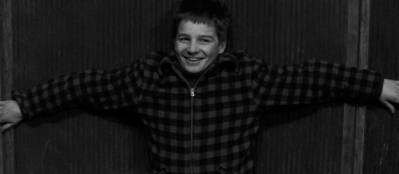 A black and white film still from The 400 Blows with Antoine on a carnival ride.