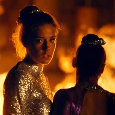 A film still from the The Five Devils of Adèle Exarchopoulos in a gymnastics uniform with flames behind her.