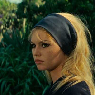 A film still from Godard's Contempt with Brigitte Bardot in profile wearing a black headband.