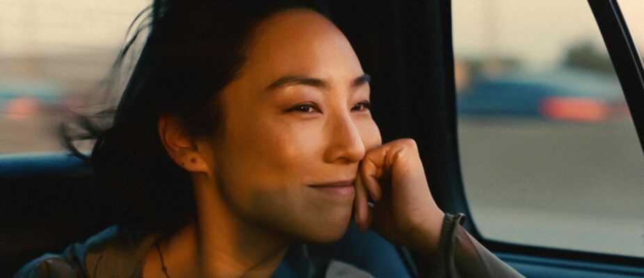 A film still from Past Lives with a closeup of Greta Lee looking out a car window.