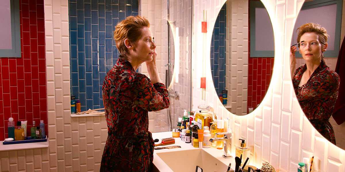A film still from The Human Voice with Tilda Swinton looking into a mirror.