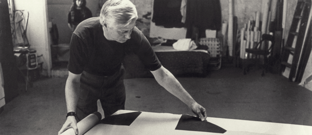 Paul Reed unrolling a painting in his studio, 1971, photo courtesy of Jean Reed Roberts.