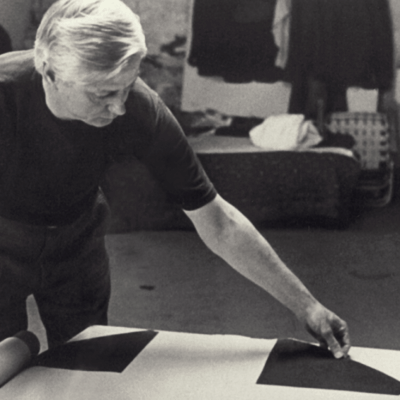 Paul Reed unrolling a painting in his studio, 1971, photo courtesy of Jean Reed Roberts.