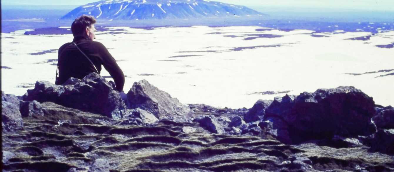 A film still from Time and Water. Icelandic Glaciological Society member, Árni Kjartansson, sits overlooking a glacier in Iceland. (Archival Materials Courtesy of Andri Snær Magnason)