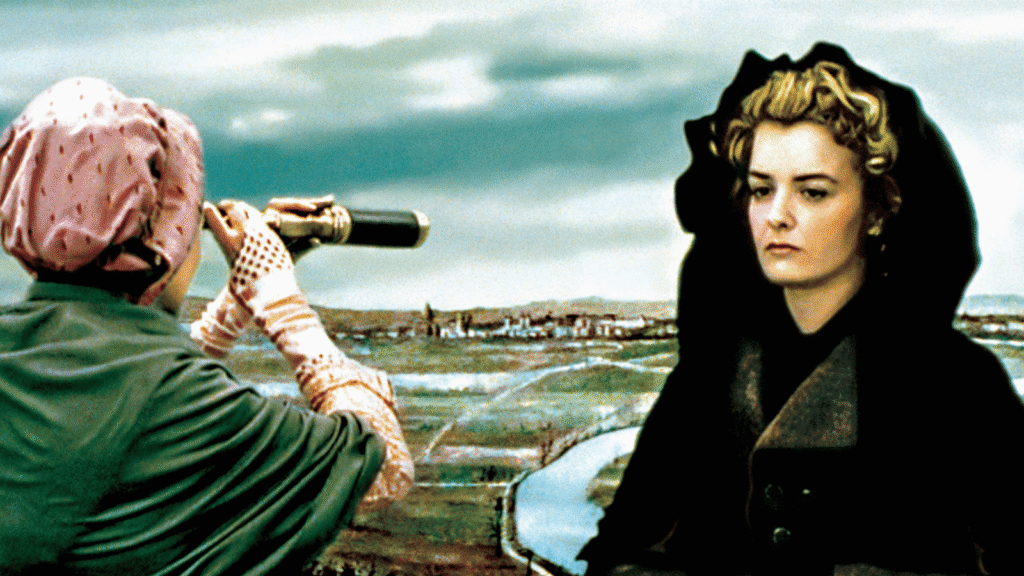 A woman in a dark coat looks away while another woman views the landscape through binoculars in a scene from The Lady and the Duke.